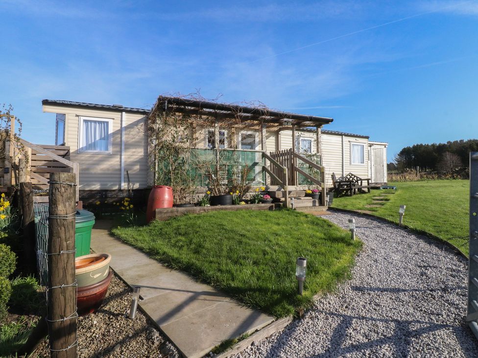 A mobile home with a deck and garden at Cornholme Lodge Accrington