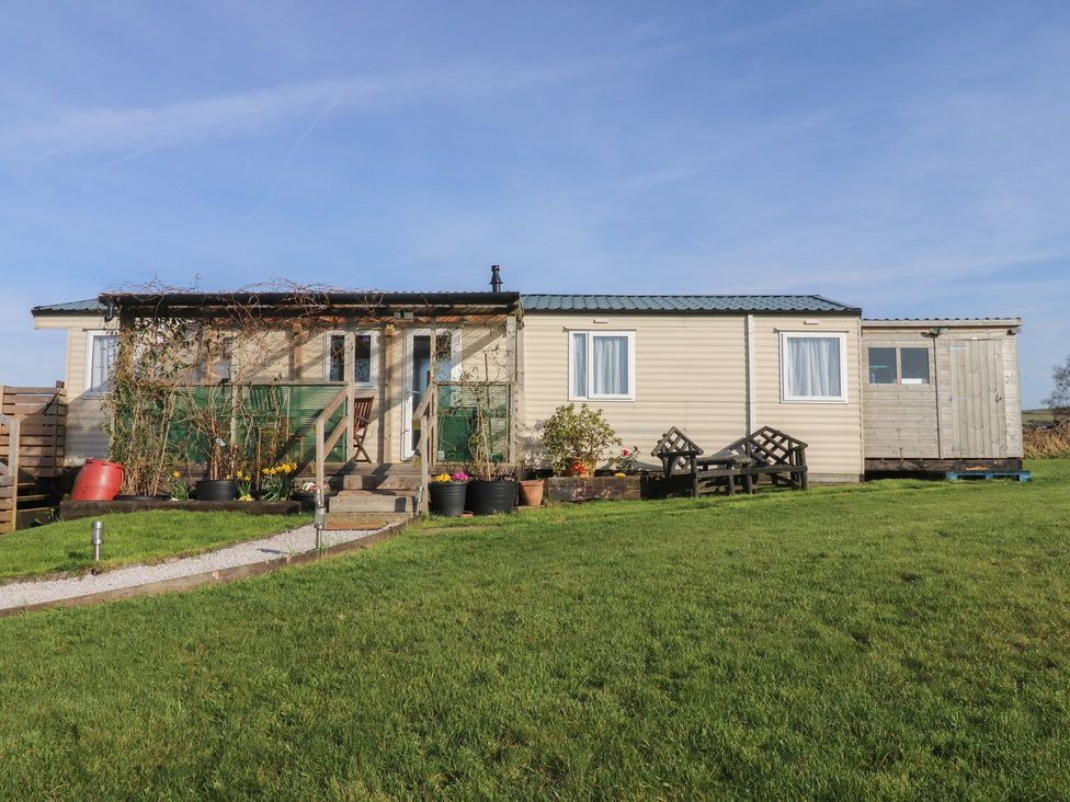 A cabin with steps and planters at Cornholme Lodge in Accrington