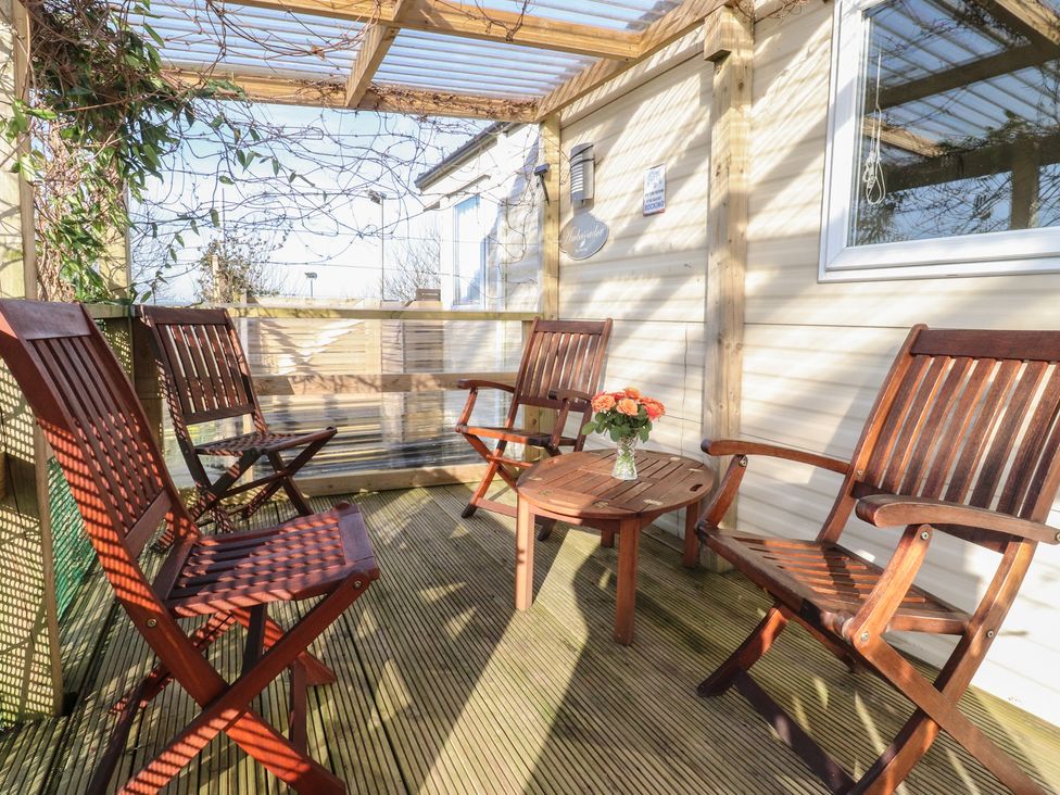A conservatory with seating and a table at Cornholme Lodge in Accrington