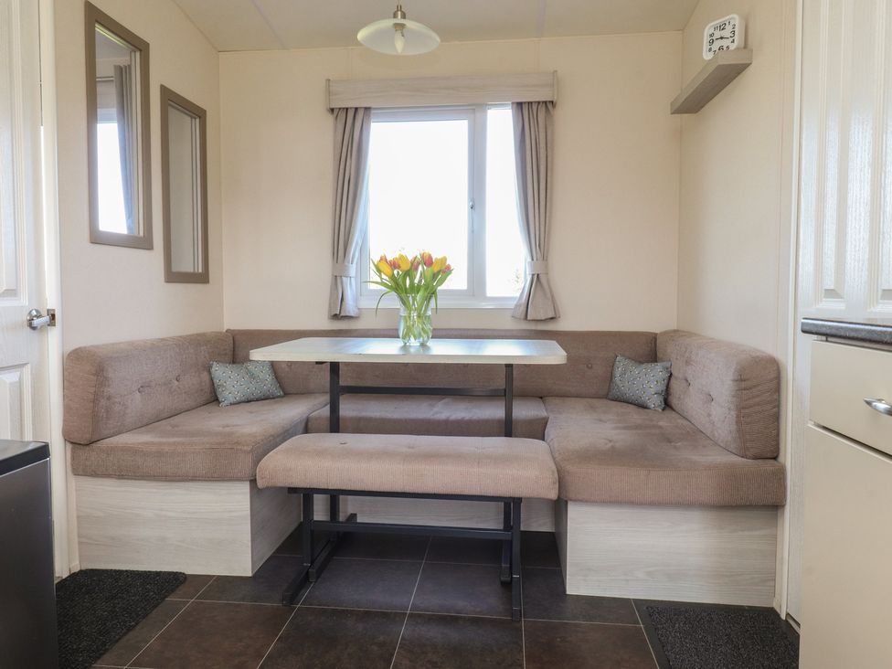 A dining room with a table and benches at Cornholme Lodge in Accrington