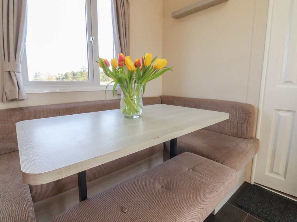A dining table with a vase of tulips at Cornholme Lodge in Accrington