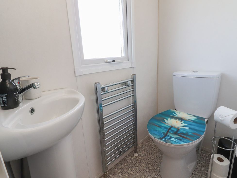 A bathroom with a sink, toilet, and towel rail at Cornholme Lodge in Accrington