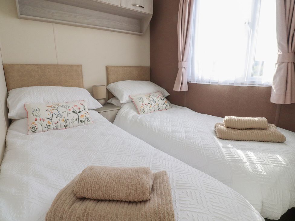 A bedroom with two single beds and a window at Cornholme Lodge in Accrington