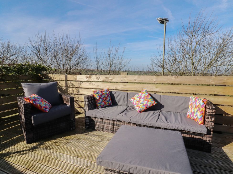 An outdoor seating area with sofa and cushions at Cornholme Lodge in Accrington