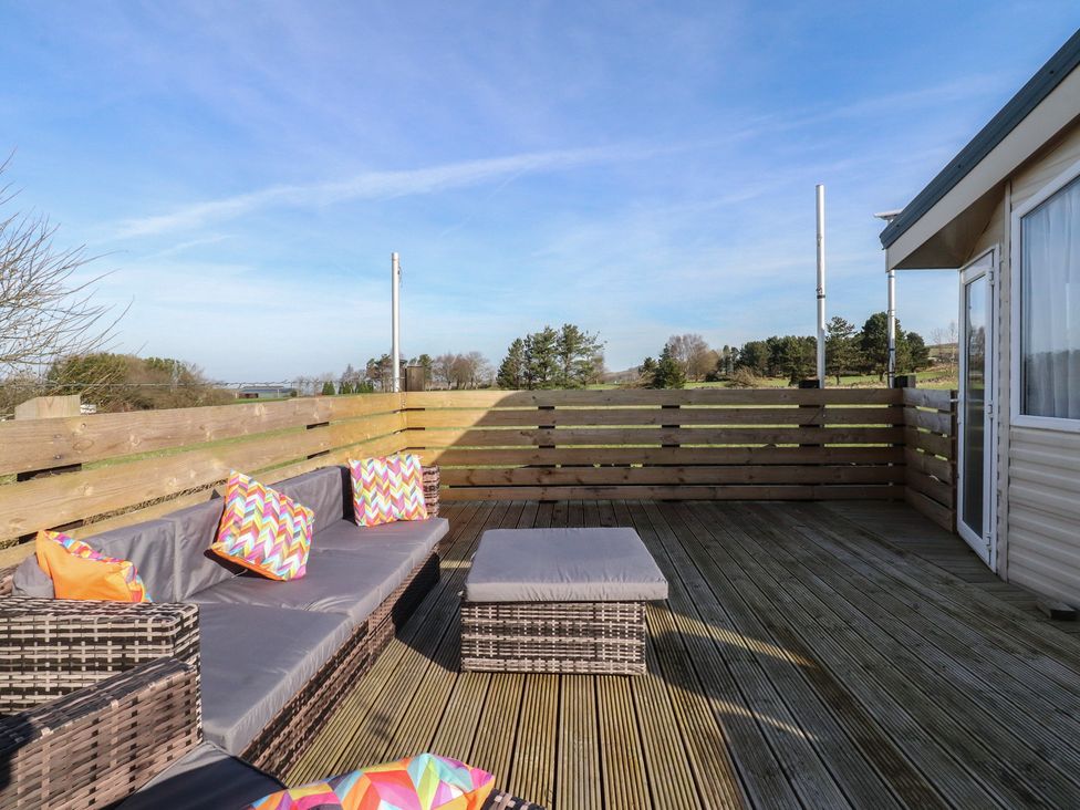 An outdoor seating area with a couch and table at Cornholme Lodge in Accrington