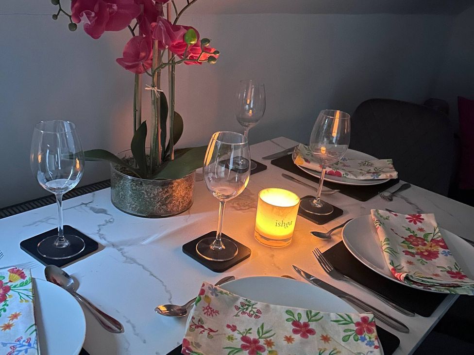 A dining room table set with wine glasses and a candle at 3 Linshader Stornoway