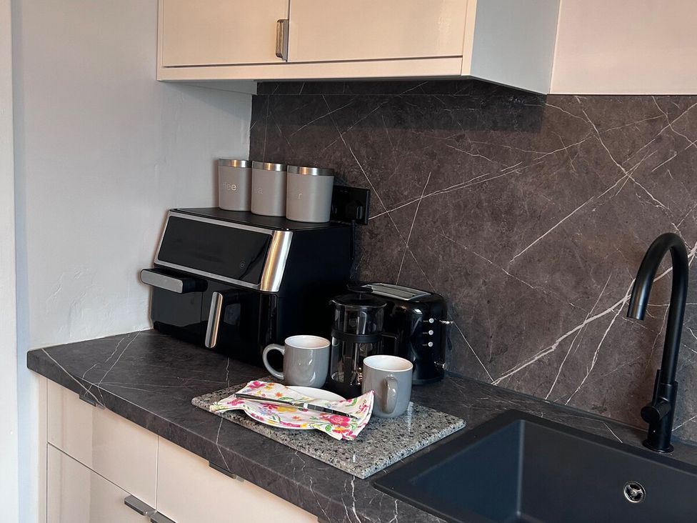 A kitchen with coffee maker and mugs at 3 Linshader in Stornoway