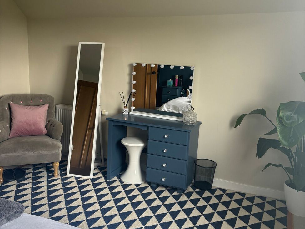 A bedroom with a dresser and mirror at 3 Linshader, Stornoway