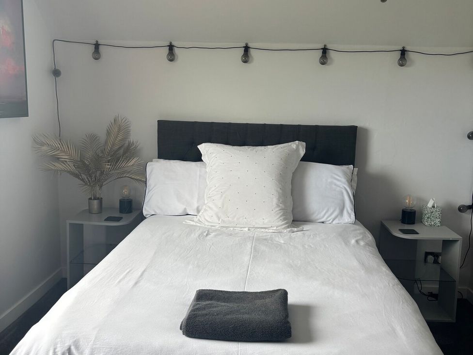 A bedroom with a bed and bedside tables at 3 Linshader Stornoway