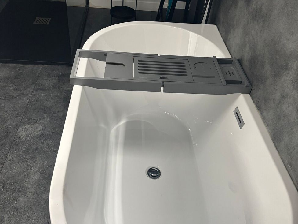 A bathtub with a tray positioned on the edge at 3 Linshader Stornoway