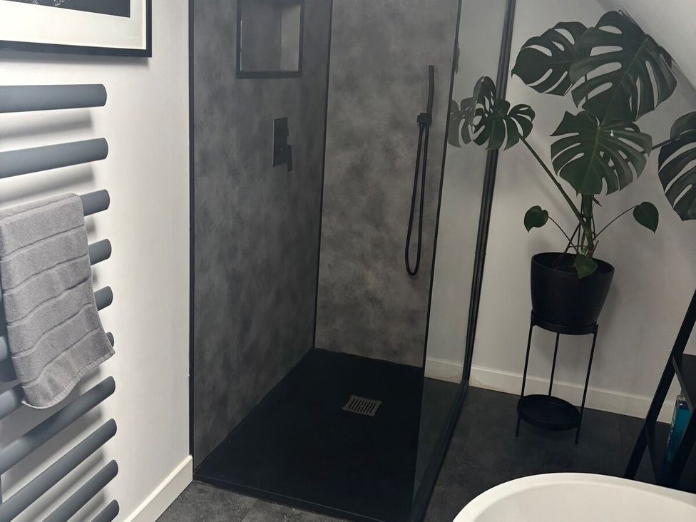 A bathroom with a shower and towel rack at 3 Linshader Stornoway