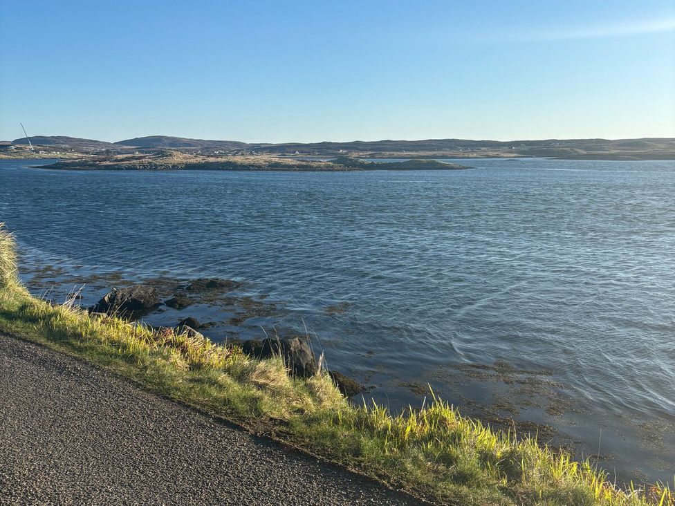 A view of water with rocks and grass at 3 Linshader Stornoway