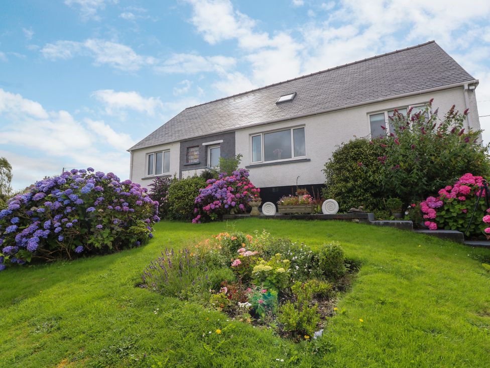 A house with flowers and shrubs in the garden at 3 Linshader, Stornoway