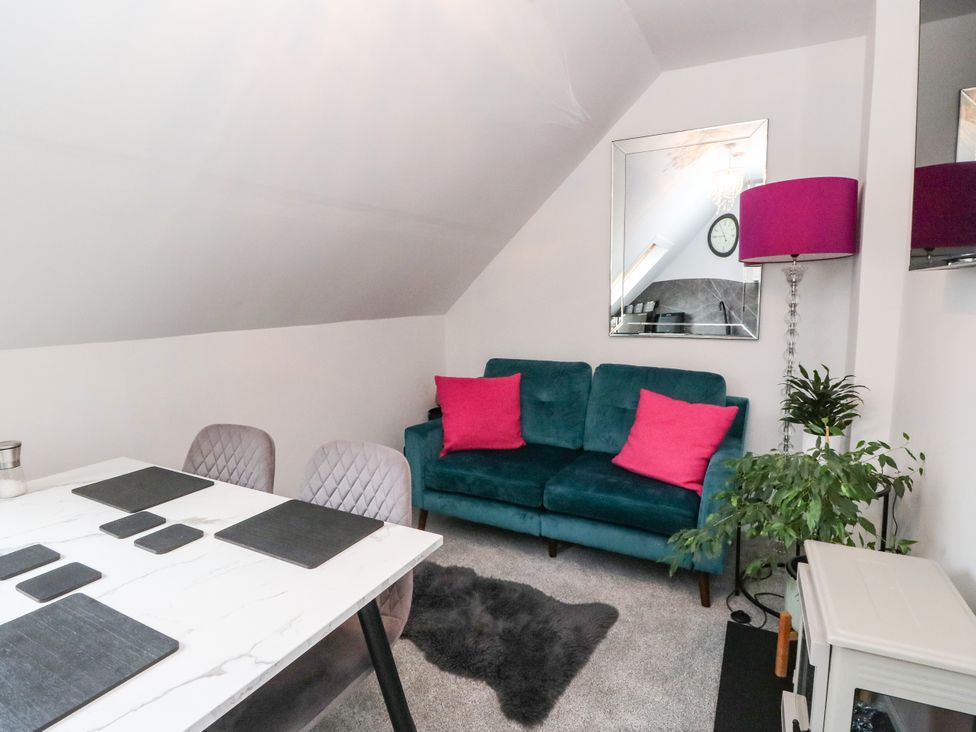 A living room with a sofa and a dining table at 3 Linshader in Stornoway