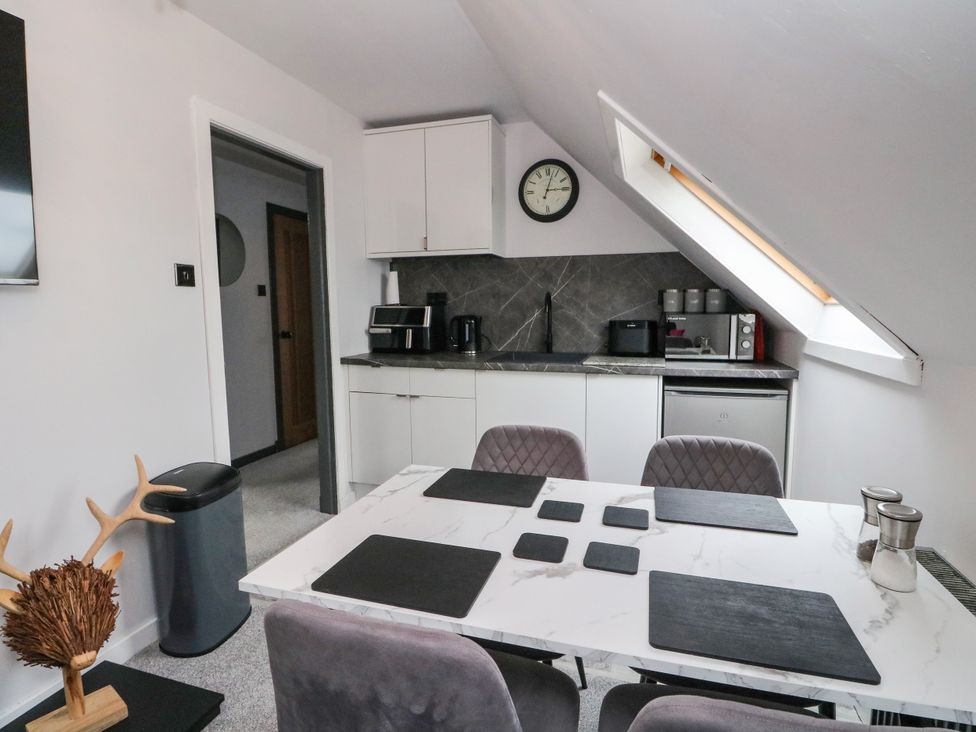 A kitchen with a table and chairs at 3 Linshader in Stornoway