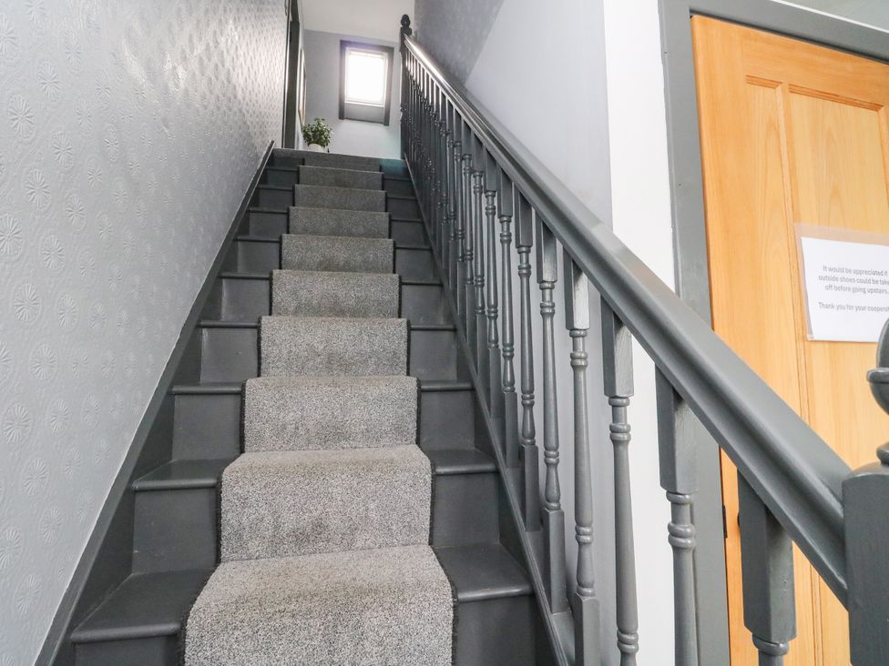 A staircase with a handrail and plant at 3 Linshader in Stornoway