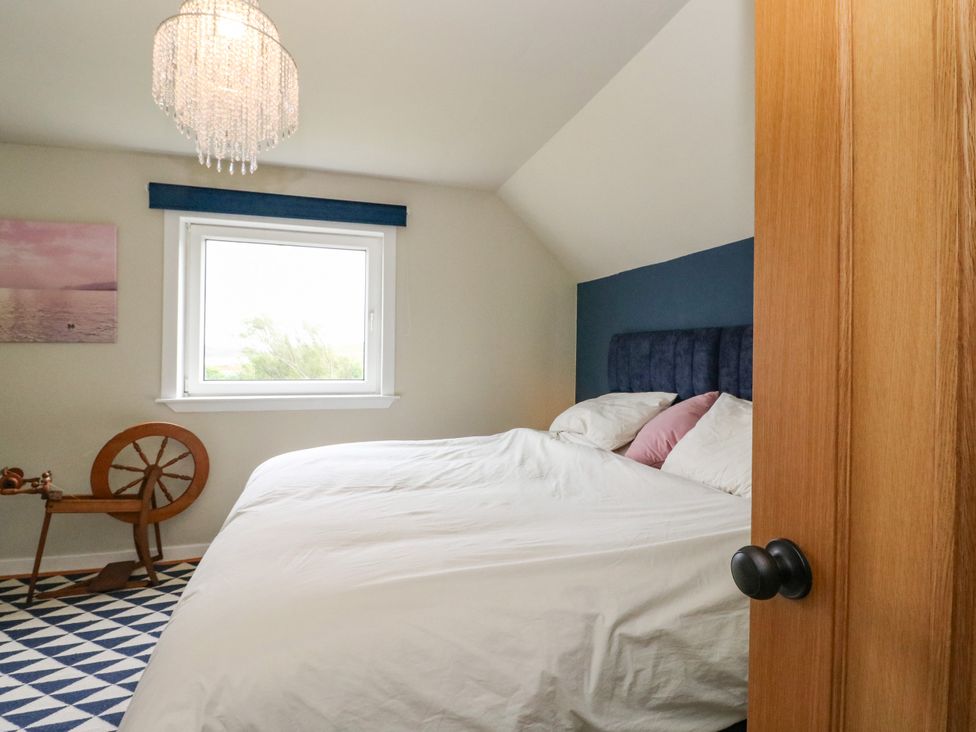 A bedroom with a bed and spinning wheel at 3 Linshader Stornoway