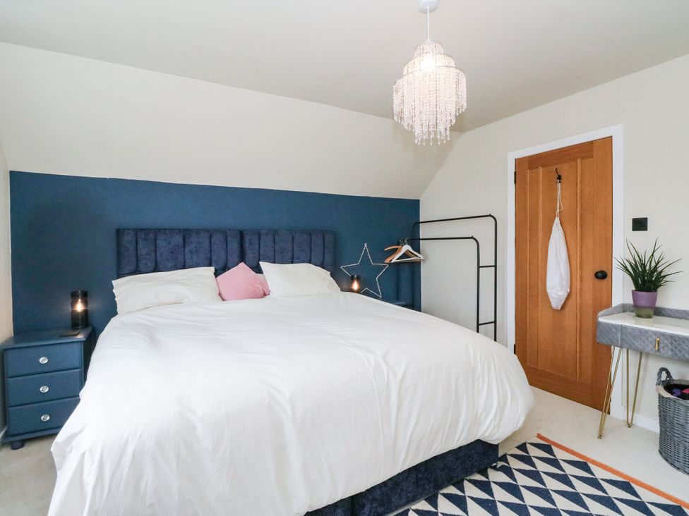 A bedroom with a bed and nightstand at 3 Linshader, Stornoway