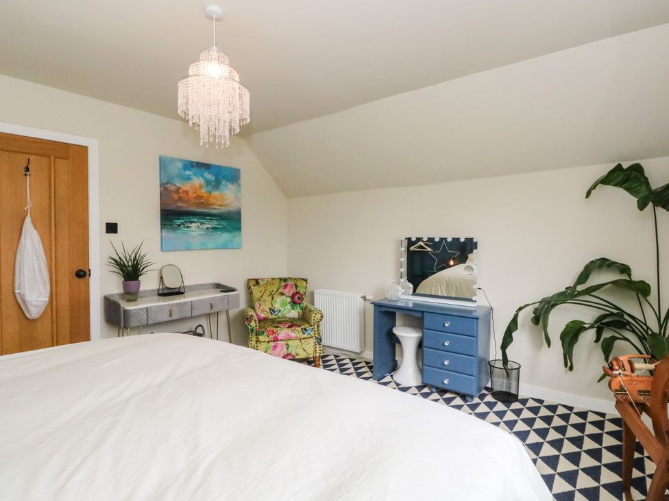 A bedroom with a bed and chair at 3 Linshader in Stornoway