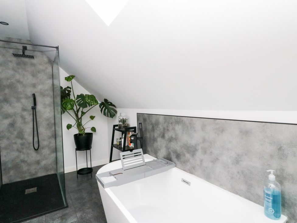 A bathroom with a bathtub and shower at 3 Linshader in Stornoway