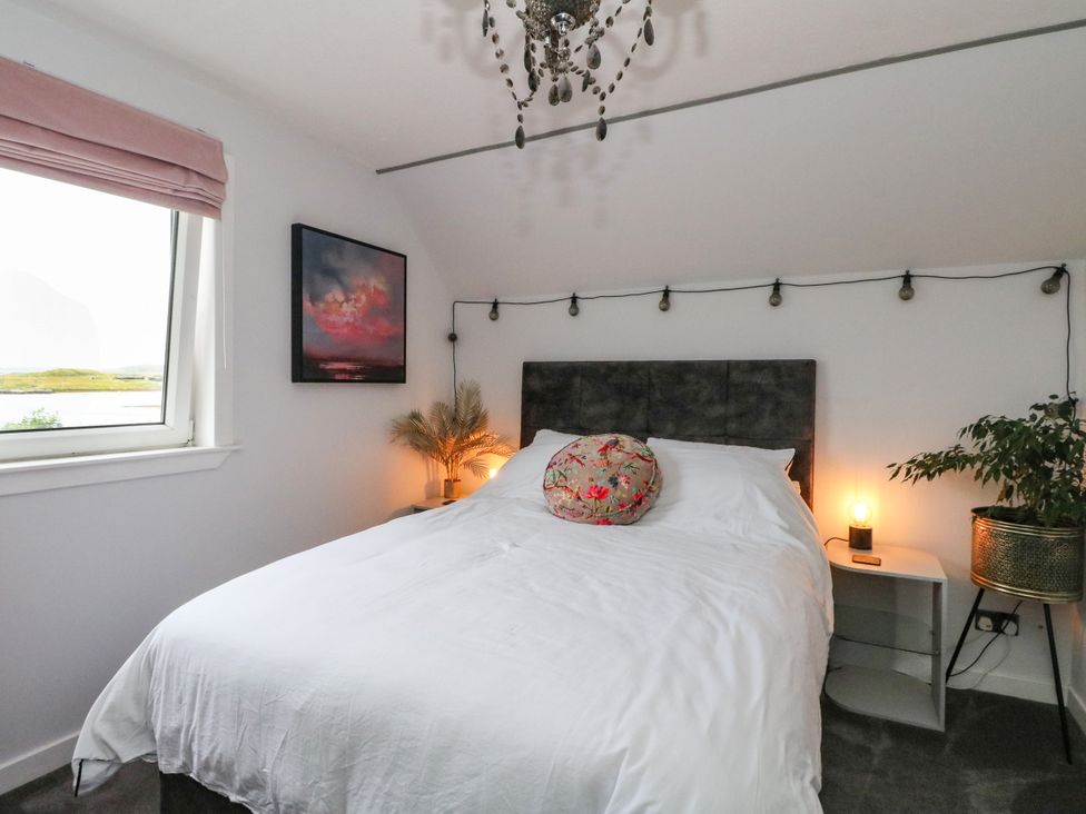 A bedroom with a bed and painting at 3 Linshader in Stornoway