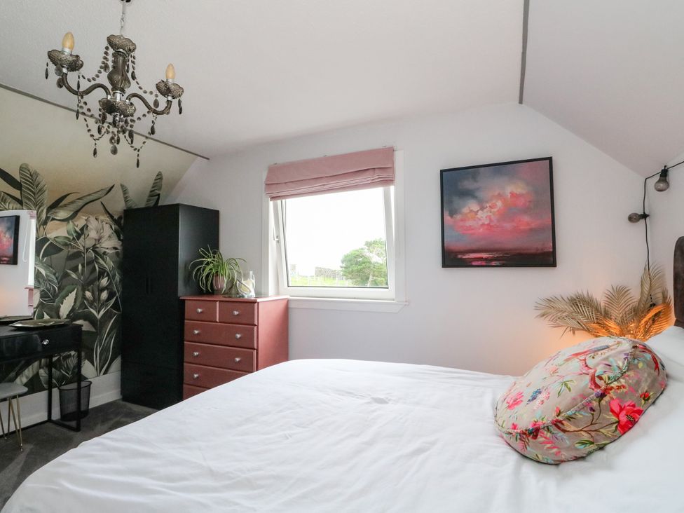 A bedroom featuring a bed, dresser and window at 3 Linshader Stornoway