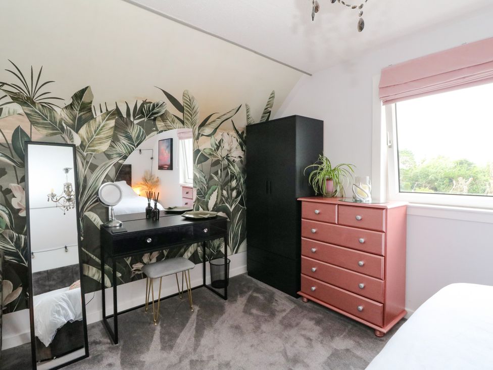 A bedroom with a vanity table and wardrobe at 3 Linshader in Stornoway