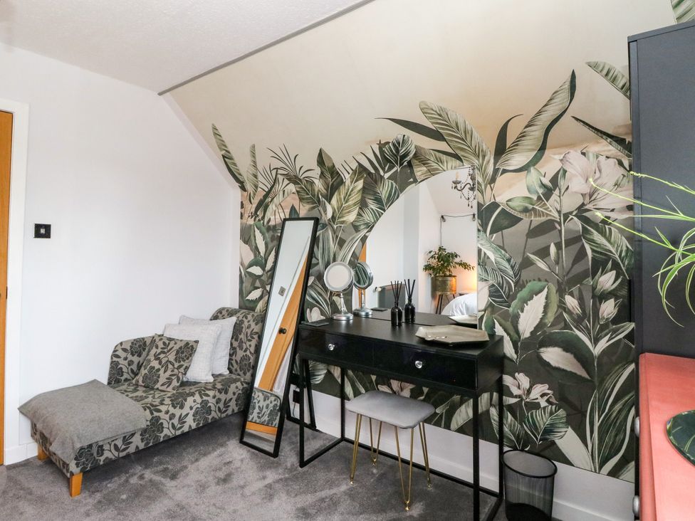 A bedroom with a vanity and a sofa at 3 Linshader in Stornoway