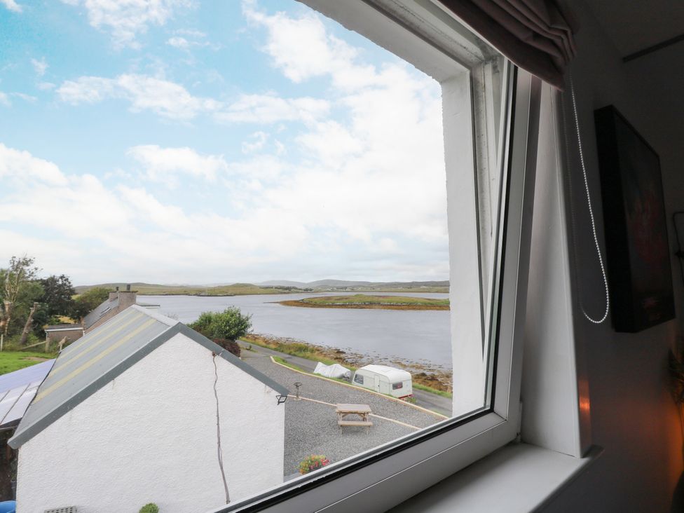 A view from a window showing a river and houses at 3 Linshader in Stornoway