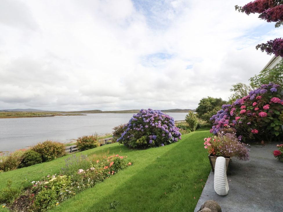 A garden with flowers and water view at 3 Linshader Stornoway