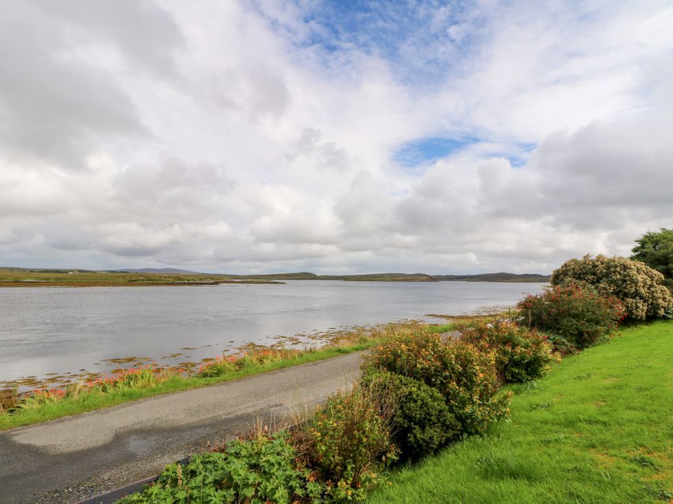 A view of a water body with a road and greenery at 3 Linshader in Stornoway