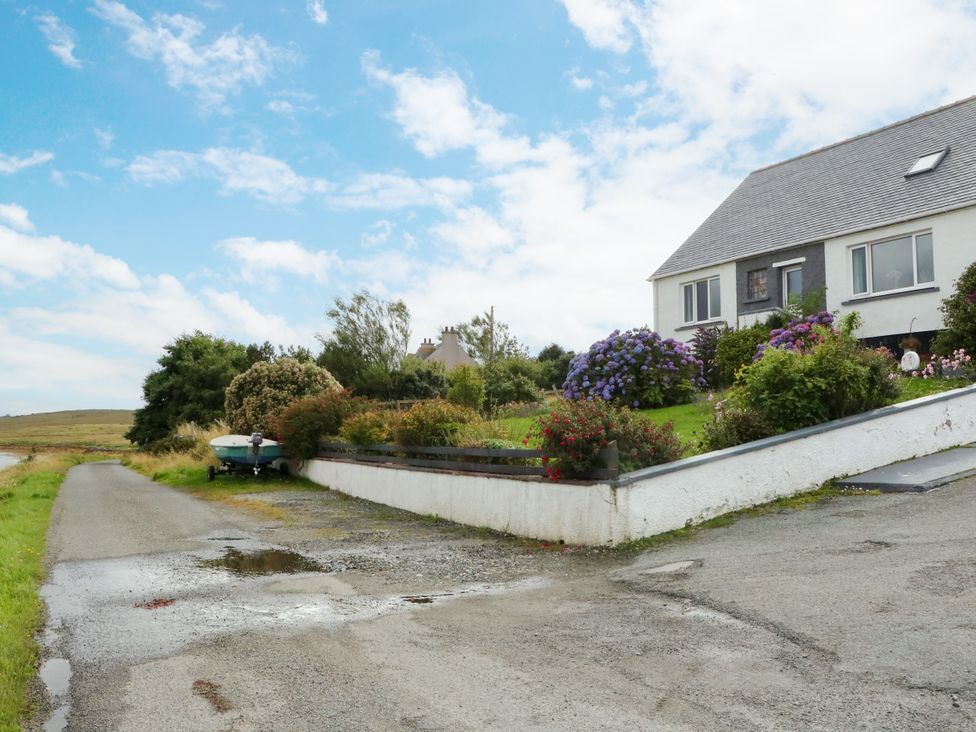 A house with a garden and a boat on the side at 3 Linshader in Stornoway