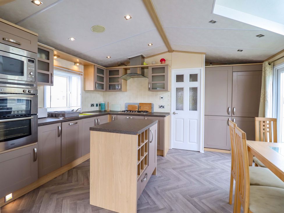 A kitchen with cabinets and appliances at Pemberton Knightsbridge in Morfa Bychan