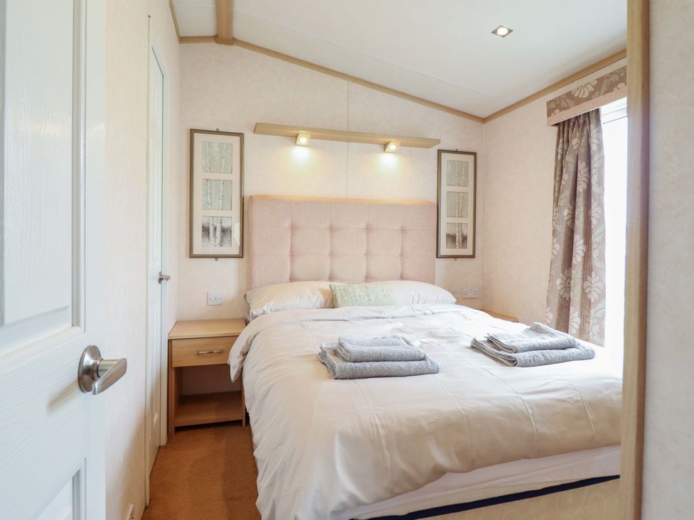 A bedroom with a bed and bedside table at Pemberton Knightsbridge in Morfa Bychan