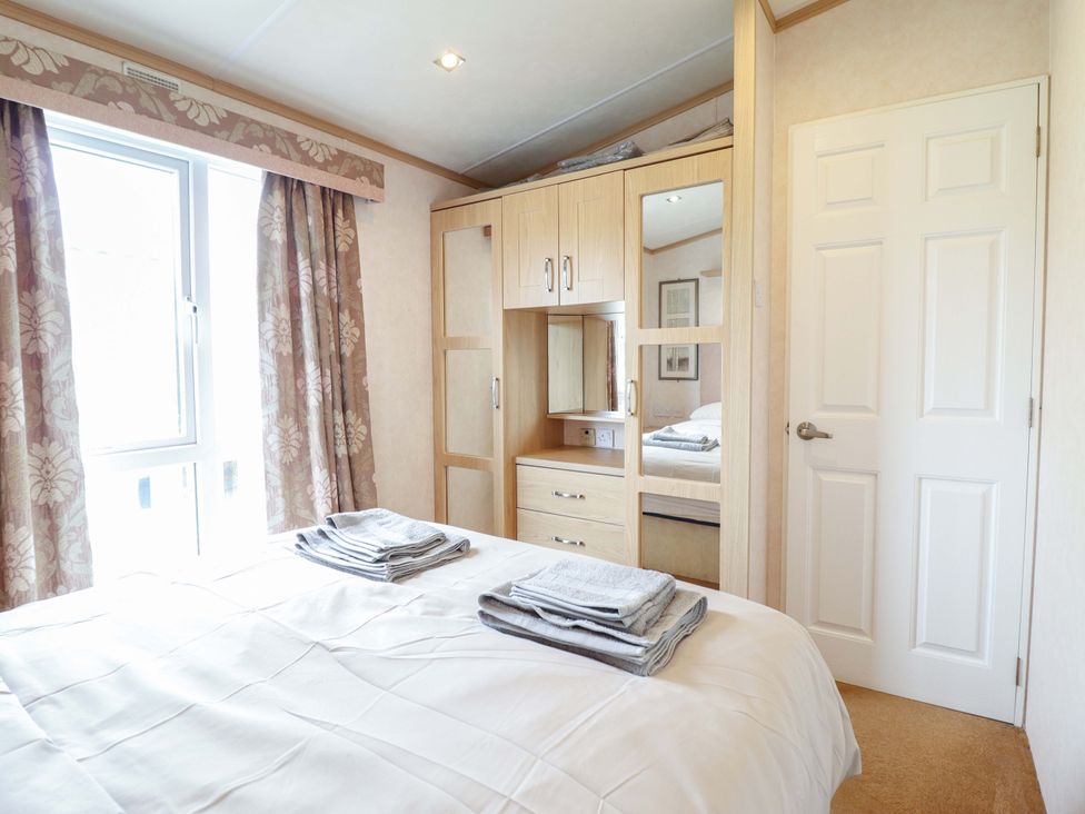 A bedroom with a bed and wardrobe at Pemberton Knightsbridge in Morfa Bychan