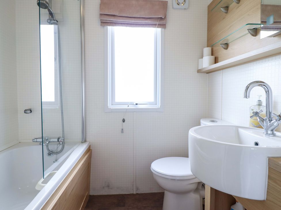 A bathroom with a bathtub and sink at Pemberton Knightsbridge Morfa Bychan