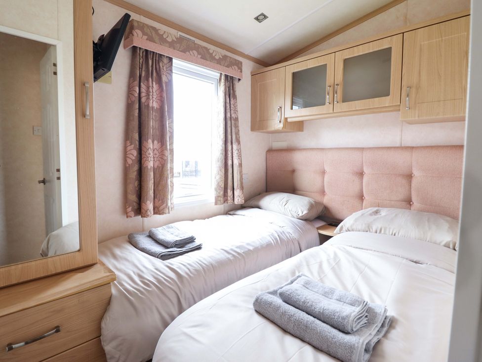 A bedroom with two beds and a mirror at Pemberton Knightsbridge in Morfa Bychan