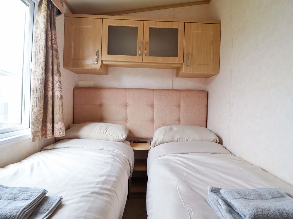 A bedroom with twin beds and wall cabinets at Pemberton Knightsbridge in Morfa Bychan
