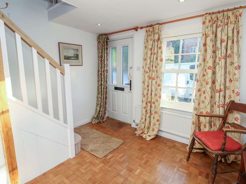 A hallway with a staircase and chair at 5 Castle Street in Newport, Isle Of Wight