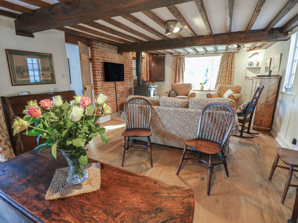 A living room with a sofa, chairs, and flowers at 5 Castle Street in Newport, Isle Of Wight