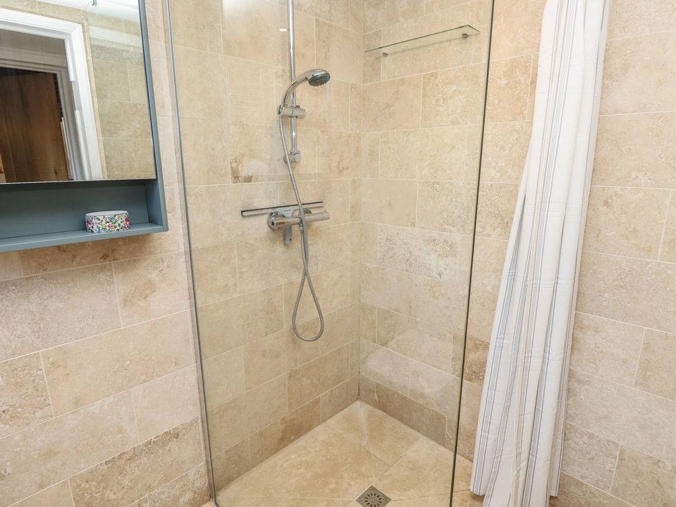 A shower with a glass panel and a shelf in 5 Castle Street, Newport, Isle Of Wight