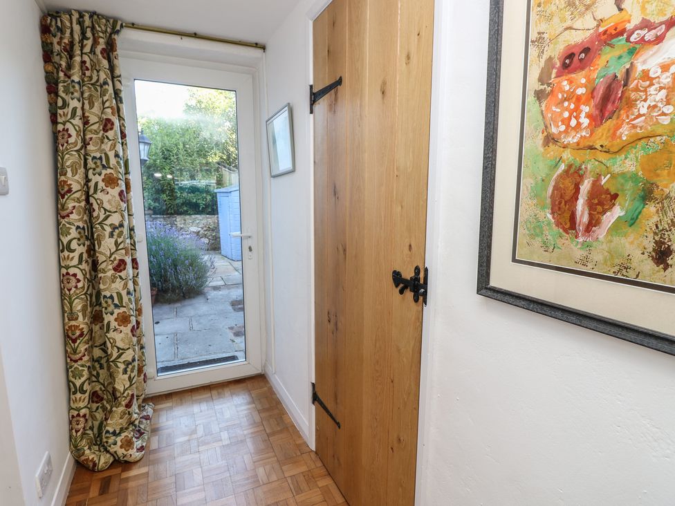 A hallway with a wooden door and a window leading to the garden at 5 Castle Street, Newport, Isle Of Wight