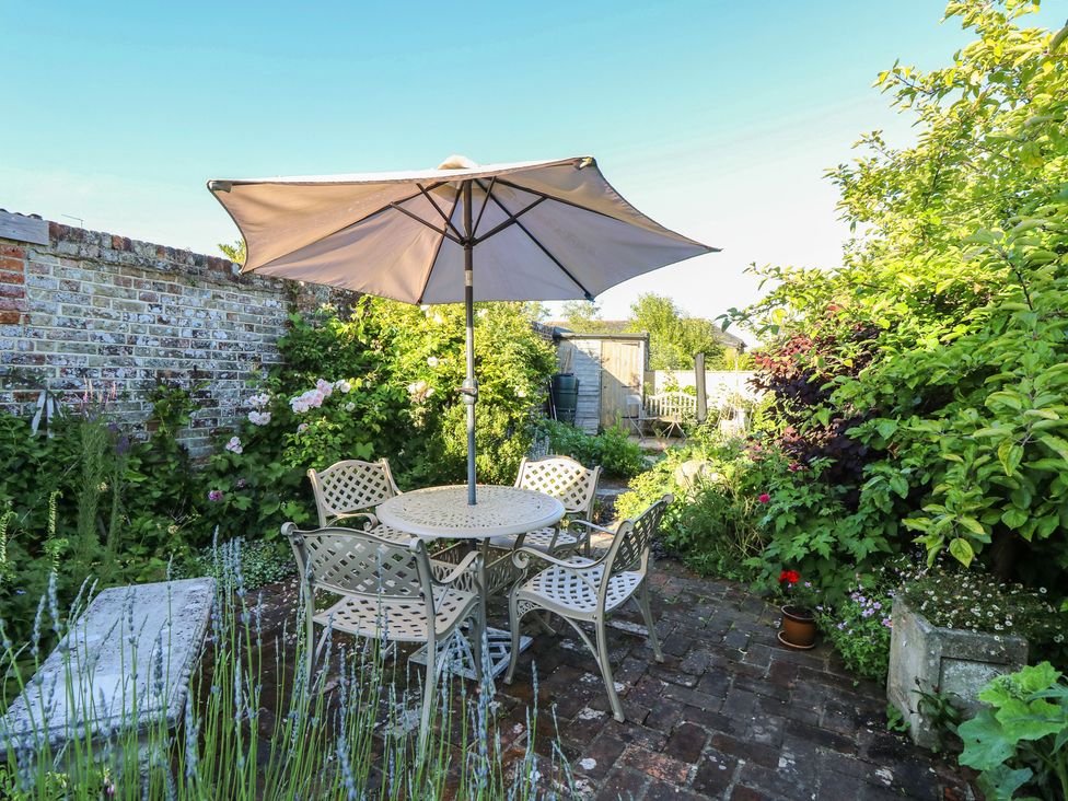 A garden with a table and chairs under an umbrella at 5 Castle Street in Newport, Isle Of Wight