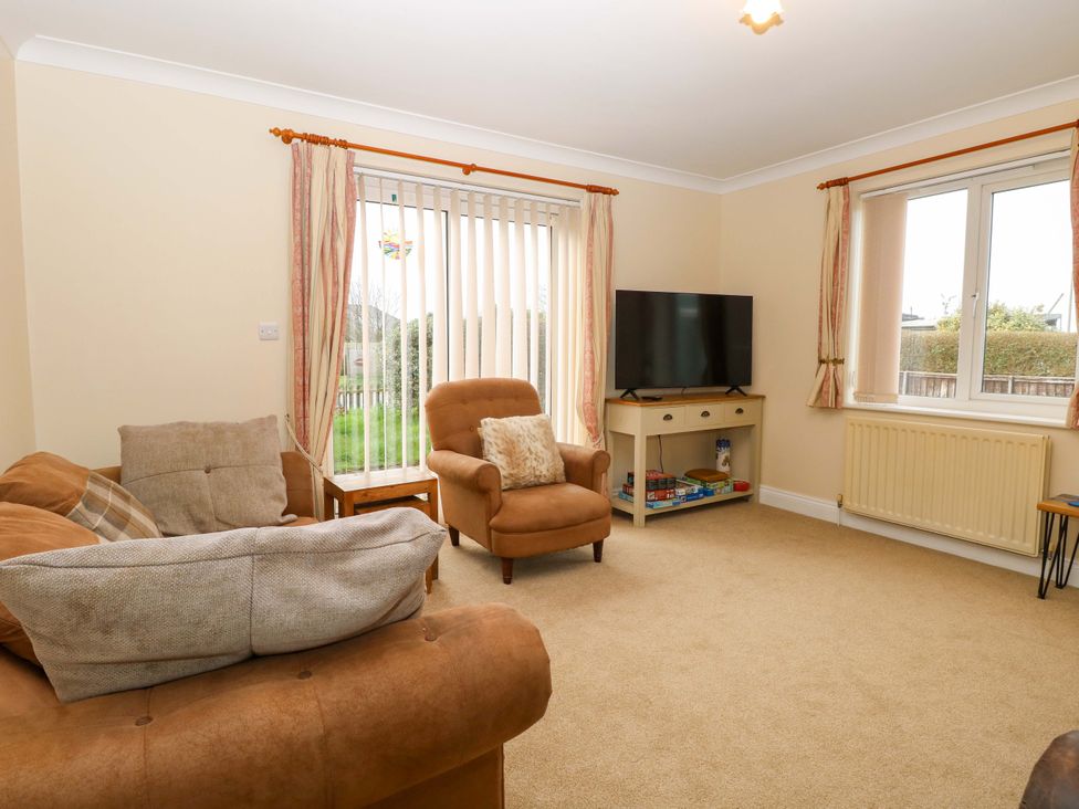 A living room with a television and seating furniture at The Bungalow in 
