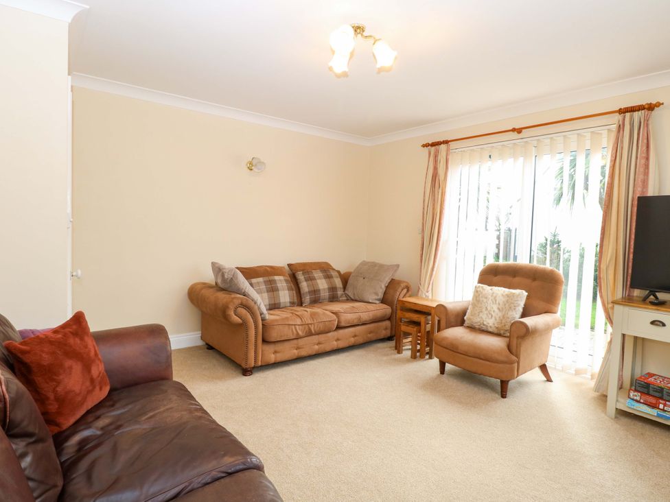 A living room with a sofa and armchair at The Bungalow