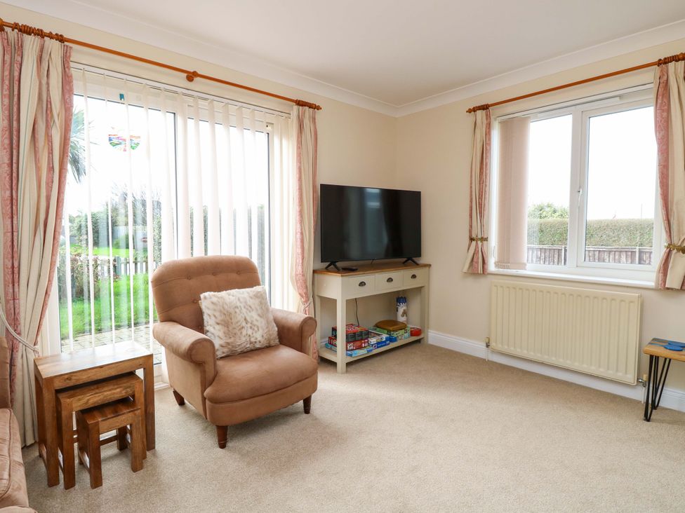 A living room with an armchair and television at The Bungalow 