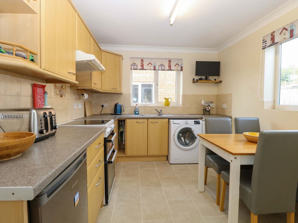 A kitchen with a dining table and appliances at The Bungalow 