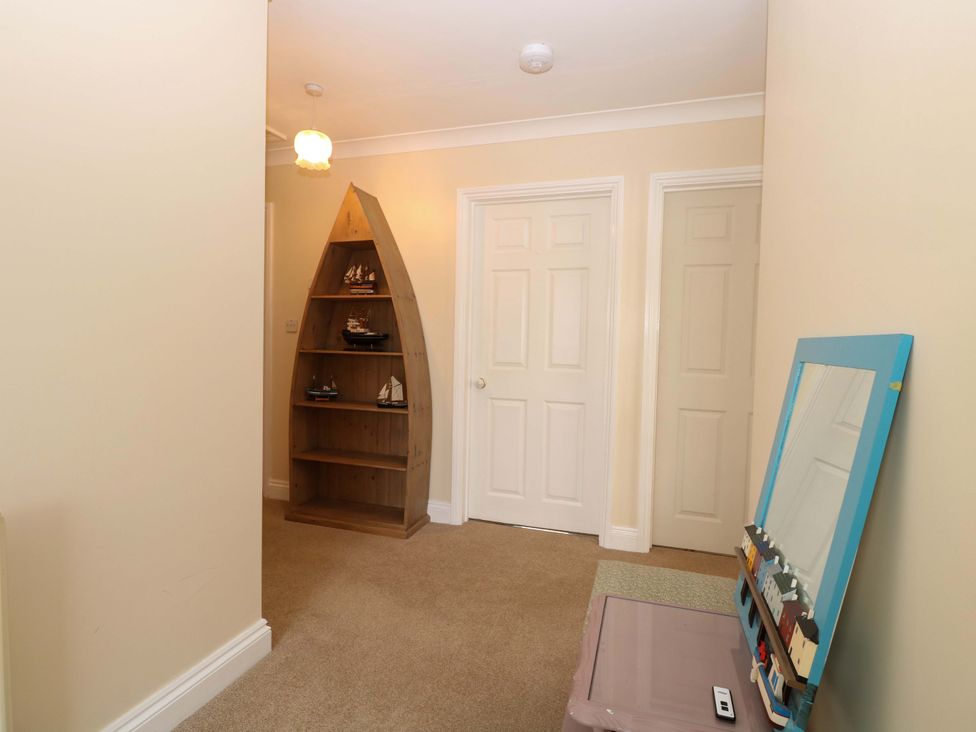 A hallway with a shelf and mirror at The Bungalow in 