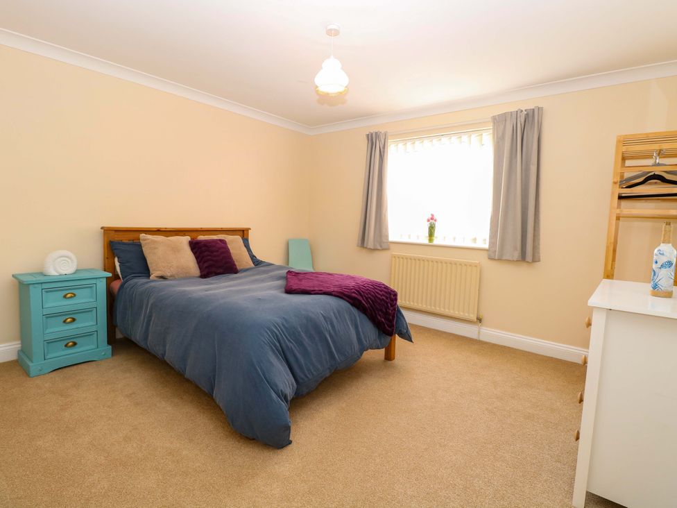 A bedroom with a bed and nightstand at The Bungalow 