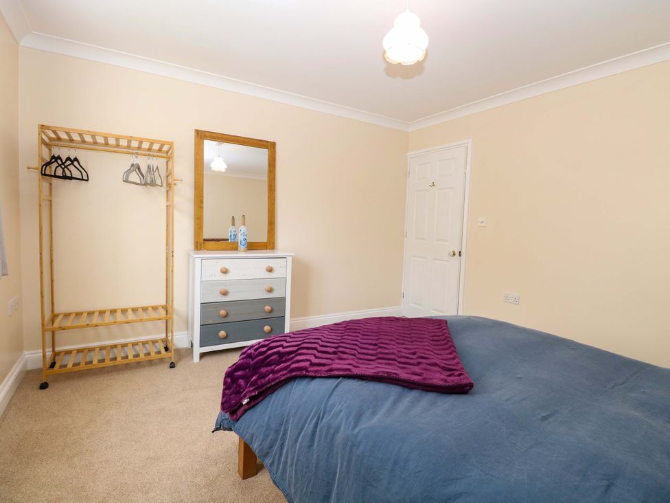 A bedroom with a bed and wardrobe at The Bungalow 